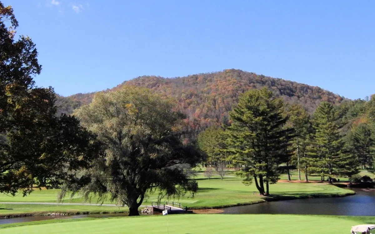 A sweeping view of a golf course, distant mountain, pond, and trees captures the grandeur of the local scenery and the range of outdoor activities available in the High Country.
