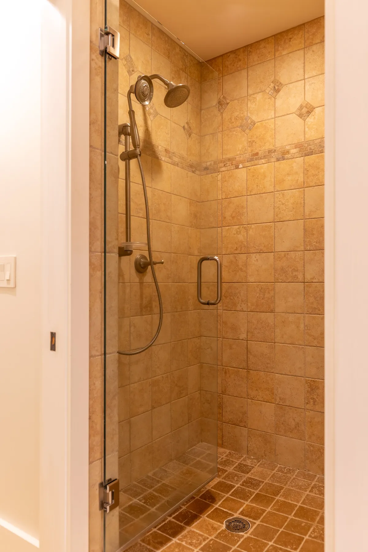 A modern bathroom with a glass shower enclosure, updated showerhead, and textured tiles, exuding a spa-like ambiance. The clean lines and tranquil tones foster an environment perfect for relaxation and self-care.